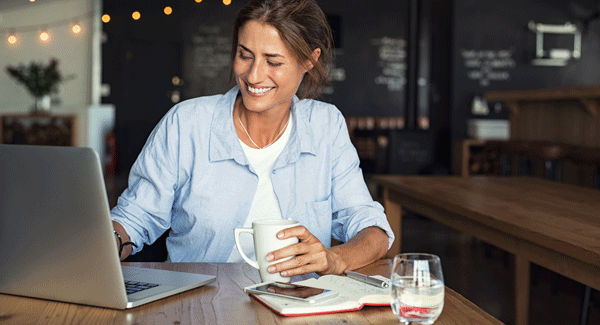 Woman at a cafe working on her laptop.