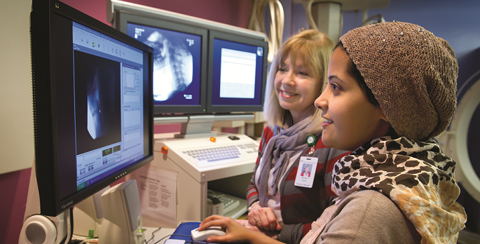 Student with clinical instructor looking at x-ray images on computer